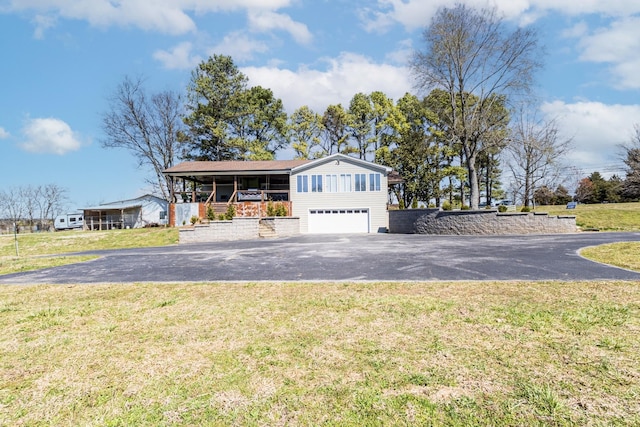 view of front of house with driveway, a front yard, and a garage