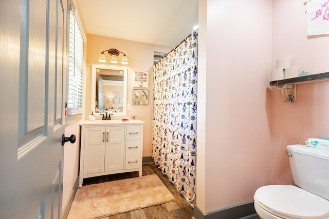 full bath with vanity, toilet, wood finished floors, a shower with shower curtain, and baseboards
