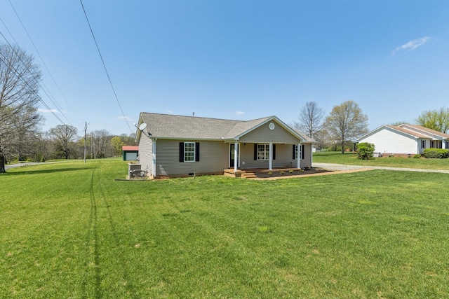 view of front of house with roof with shingles, covered porch, and a front lawn