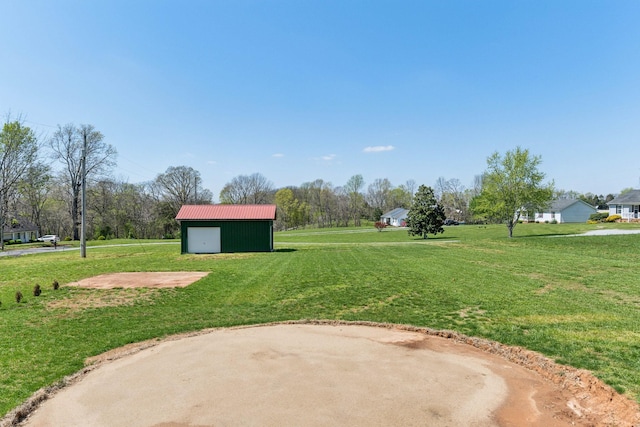 view of yard with an outbuilding, driveway, a garage, and a pole building