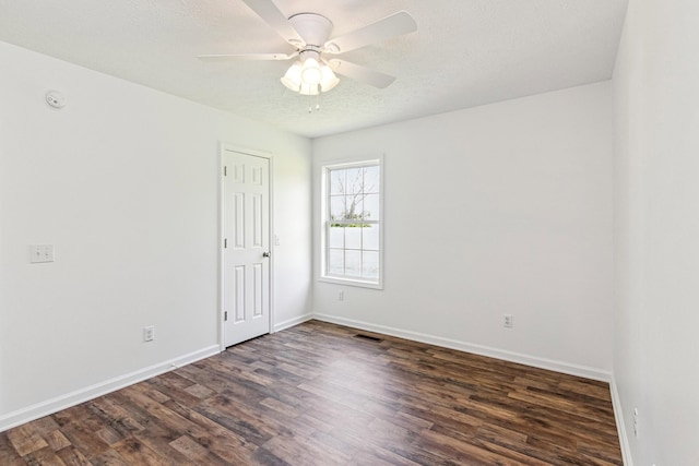 unfurnished room with ceiling fan, baseboards, visible vents, and wood finished floors