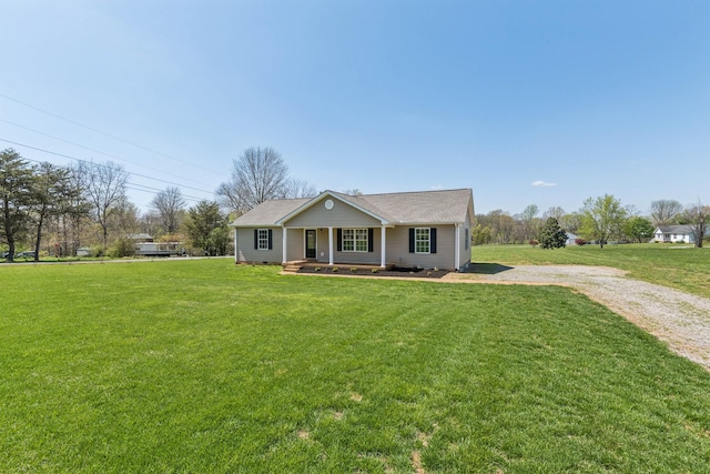 view of front facade with driveway, a front yard, and covered porch