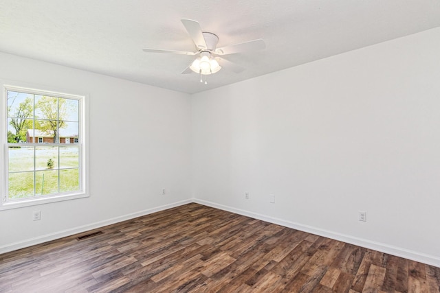 unfurnished room featuring ceiling fan, baseboards, dark wood finished floors, and visible vents