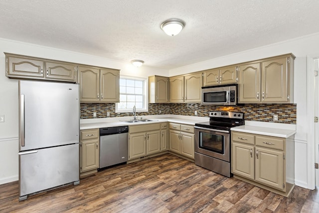 kitchen with light countertops, a textured ceiling, appliances with stainless steel finishes, and a sink