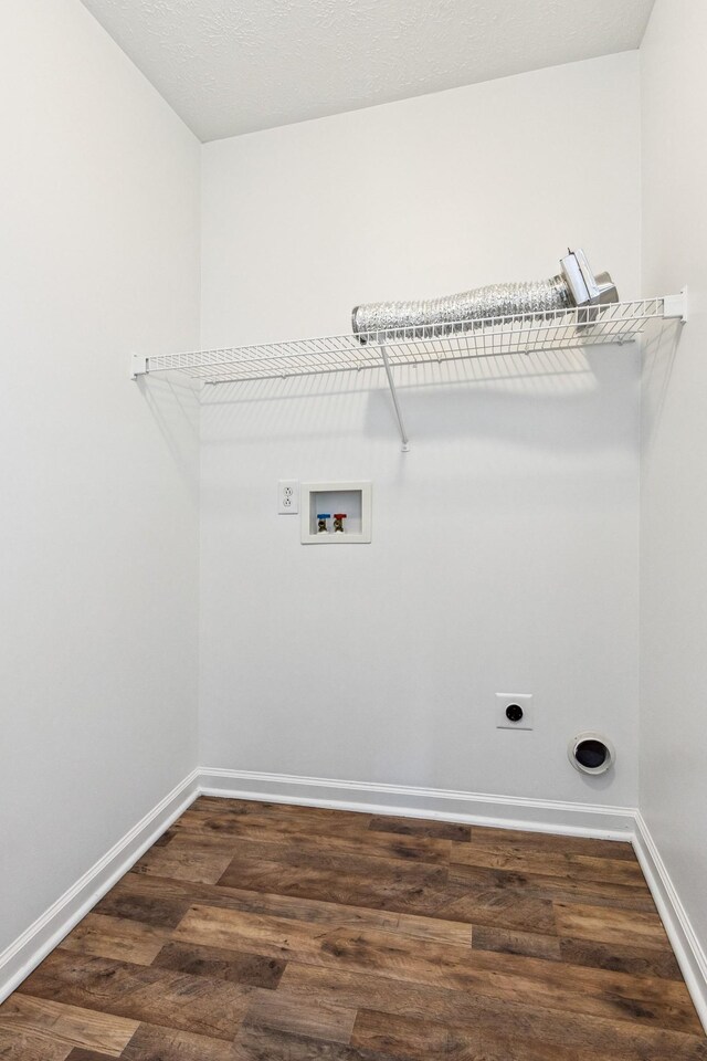laundry area with laundry area, dark wood finished floors, electric dryer hookup, washer hookup, and baseboards