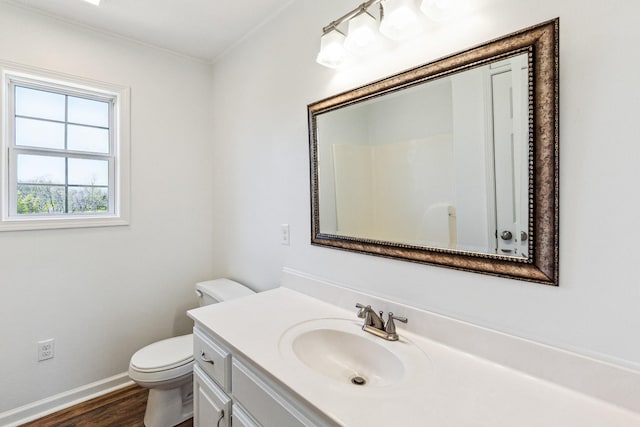 bathroom with toilet, wood finished floors, vanity, and baseboards