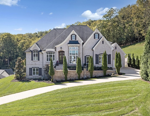 700 Pendragon Ct, Franklin, TN 37067 - french country inspired facade featuring driveway, a front lawn, and brick siding