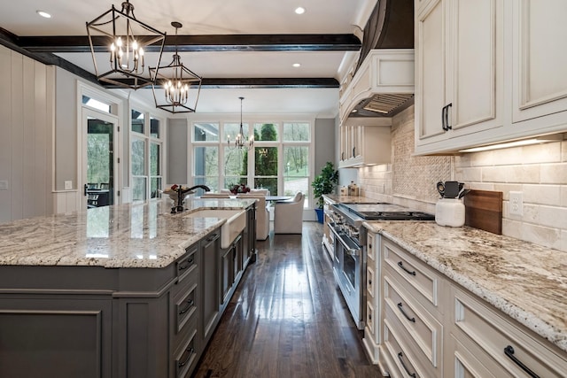 700 Pendragon Ct, Franklin, TN 37067 - kitchen featuring a sink, range with two ovens, a chandelier, and light stone countertops