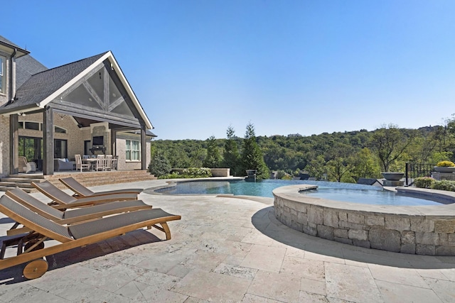 700 Pendragon Ct, Franklin, TN 37067 - view of pool with an infinity pool, a patio, an in ground hot tub, and a view of trees