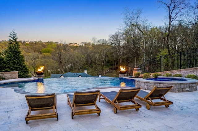 700 Pendragon Ct, Franklin, TN 37067 - pool at dusk featuring a patio area, an infinity pool, a fire pit, and an in ground hot tub