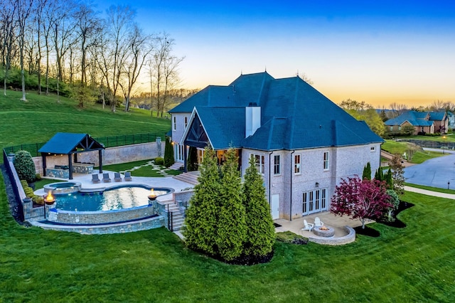 700 Pendragon Ct, Franklin, TN 37067 - back of property featuring a patio, a pool with connected hot tub, a fenced backyard, and a lawn