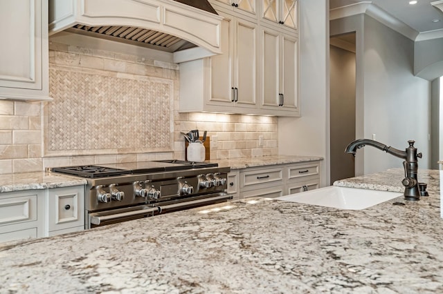 700 Pendragon Ct, Franklin, TN 37067 - kitchen with light stone countertops, tasteful backsplash, double oven range, custom exhaust hood, and a sink