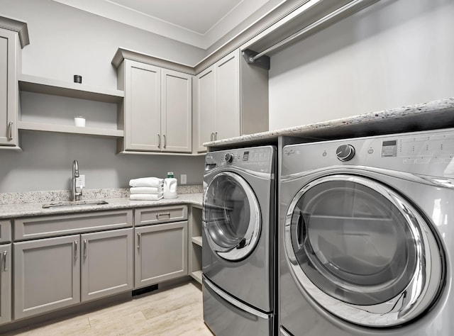700 Pendragon Ct, Franklin, TN 37067 - laundry room with a sink, cabinet space, washing machine and dryer, and light wood finished floors