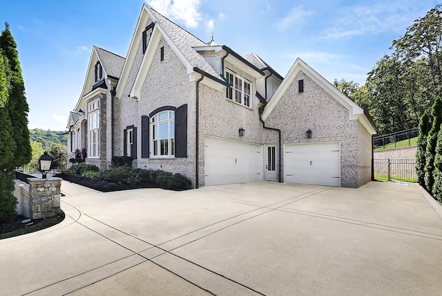 700 Pendragon Ct, Franklin, TN 37067 - view of property exterior featuring an attached garage, driveway, fence, and brick siding
