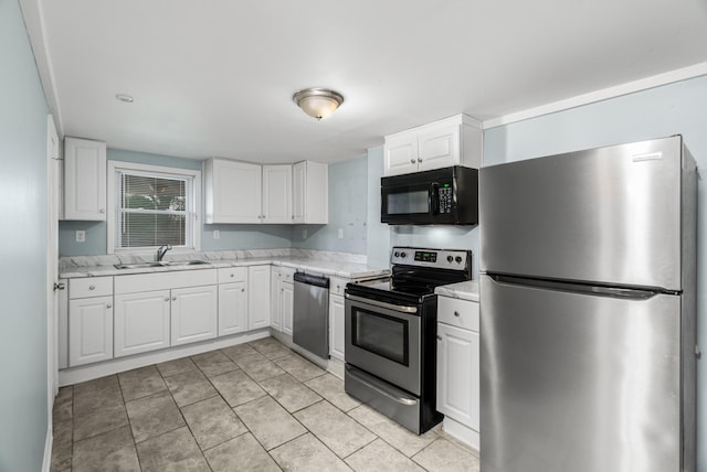 kitchen featuring stainless steel appliances, a sink, white cabinets, and light tile patterned floors