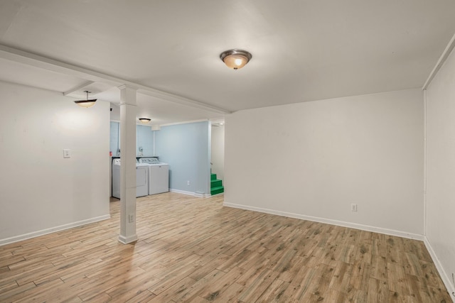 basement featuring independent washer and dryer, light wood-style flooring, baseboards, and stairs