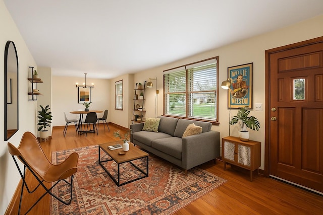 living area with wood finished floors, a chandelier, and baseboards