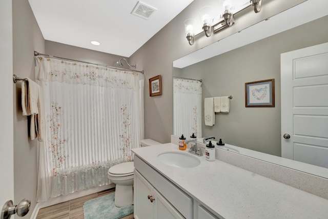 bathroom with visible vents, toilet, shower / tub combo with curtain, and vanity