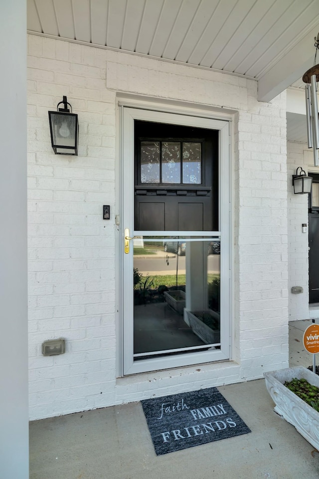 view of exterior entry featuring brick siding