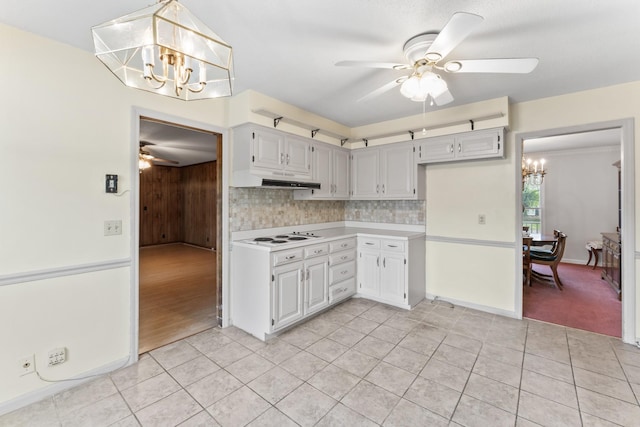 3720 Priest Lake Dr, Nashville, TN 37217 - kitchen with decorative backsplash, under cabinet range hood, light tile patterned flooring, light countertops, and ceiling fan with notable chandelier