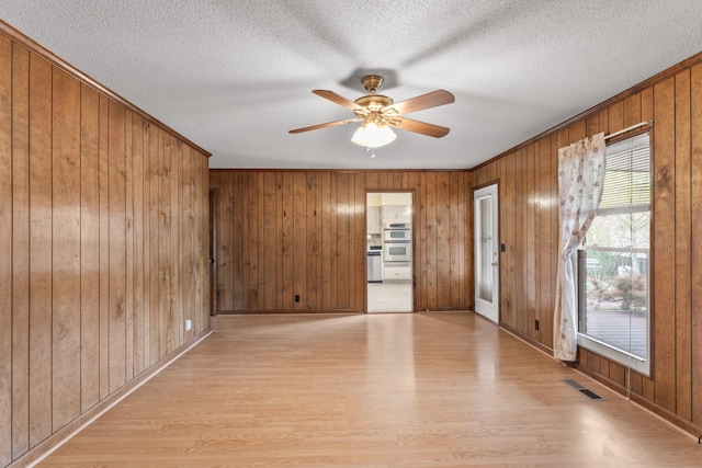 3720 Priest Lake Dr, Nashville, TN 37217 - empty room with light wood-style flooring, baseboards, visible vents, a ceiling fan, and wooden walls
