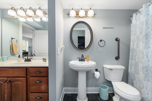 bathroom featuring tile patterned floors, baseboards, a sink, and toilet
