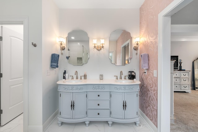 full bathroom featuring marble finish floor, double vanity, baseboards, and a sink