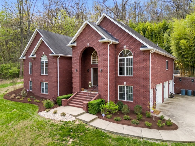 view of front of property featuring an attached garage, driveway, a front lawn, and brick siding