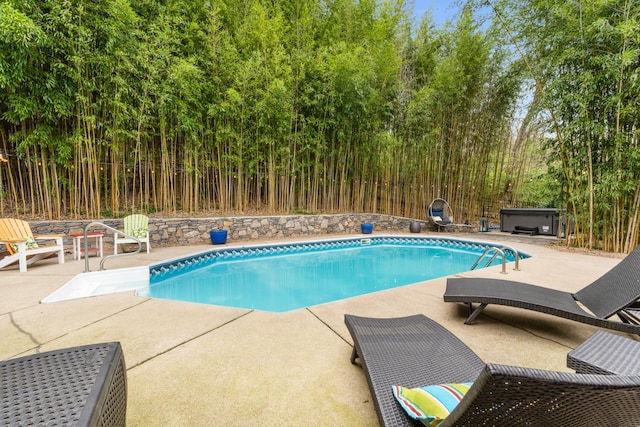 outdoor pool with a hot tub and a patio