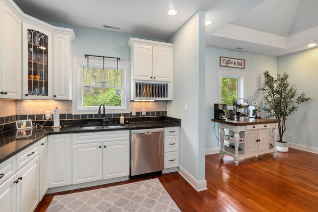 kitchen featuring tasteful backsplash, visible vents, a sink, dark wood-style flooring, and stainless steel dishwasher