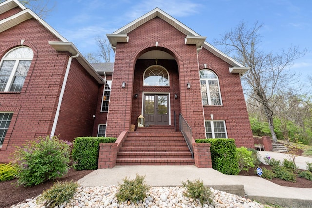 property entrance featuring french doors and brick siding