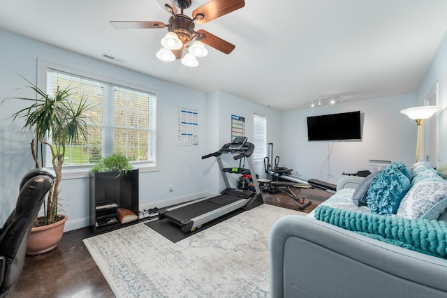 workout area with rail lighting, a healthy amount of sunlight, a ceiling fan, and visible vents