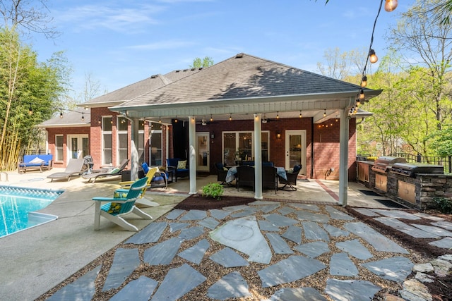 back of house with exterior kitchen, a patio area, brick siding, and french doors