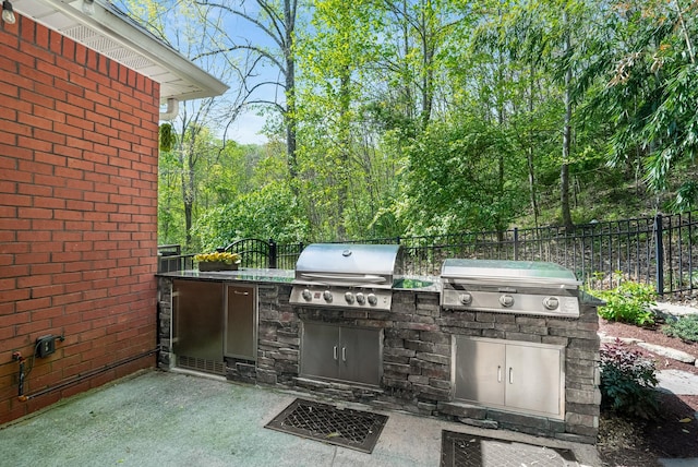 view of patio / terrace with area for grilling, a grill, and fence