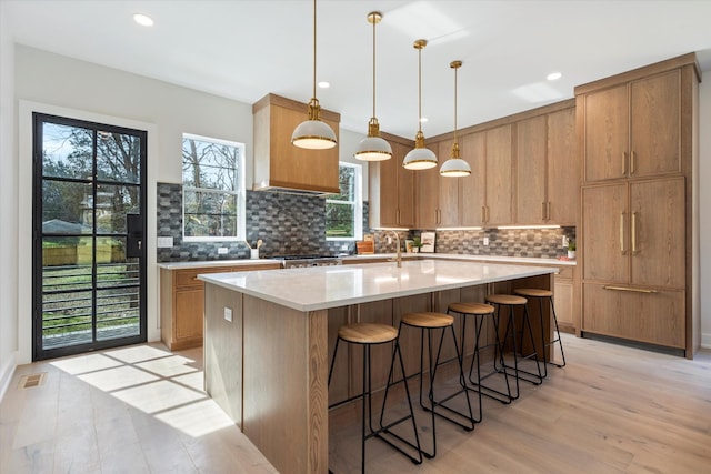 819 Davidson Dr, Nashville, TN 37205 - kitchen featuring a breakfast bar, light wood-type flooring, light countertops, backsplash, and visible vents