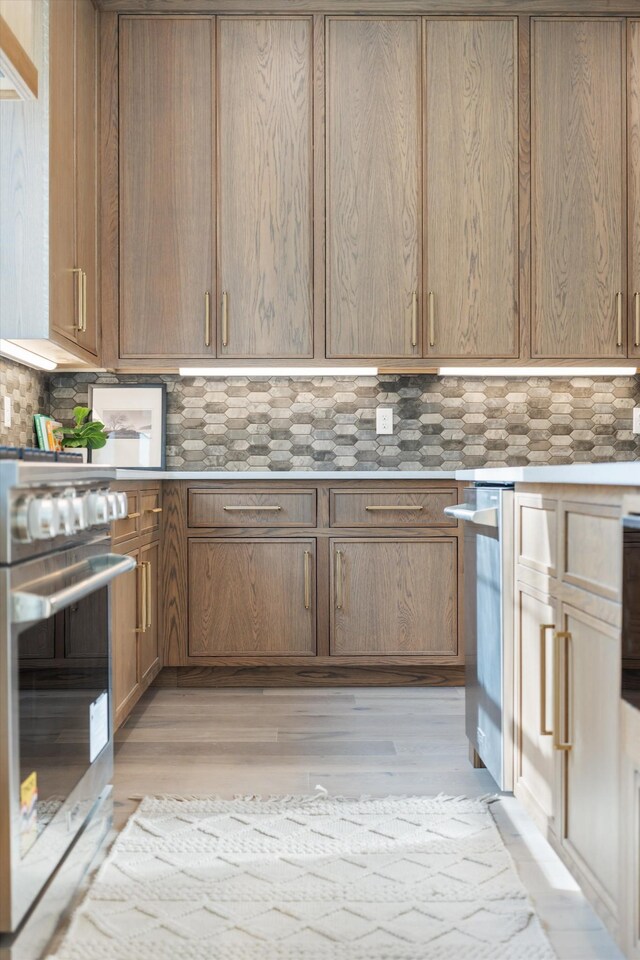 819 Davidson Dr, Nashville, TN 37205 - kitchen with light wood-style flooring, stainless steel gas range, light countertops, and backsplash