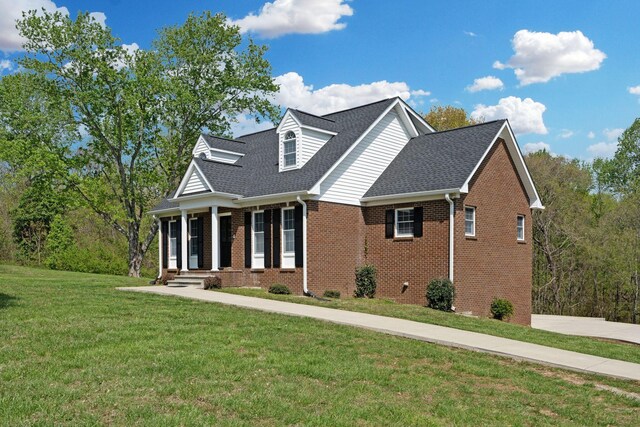 1719 Wynnewood Dr, Chapmansboro, TN 37035 - view of front facade with concrete driveway, brick siding, a shingled roof, and a front yard