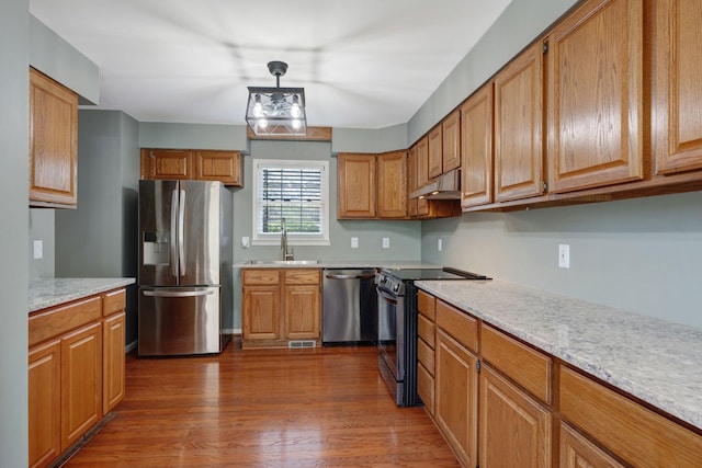 1719 Wynnewood Dr, Chapmansboro, TN 37035 - kitchen with a sink, brown cabinets, appliances with stainless steel finishes, under cabinet range hood, and dark wood-type flooring
