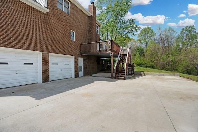 1719 Wynnewood Dr, Chapmansboro, TN 37035 - view of home's exterior with driveway, a chimney, brick siding, stairway, and a deck