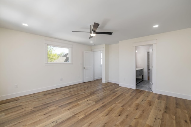 unfurnished bedroom with recessed lighting, light wood-style floors, baseboards, and connected bathroom