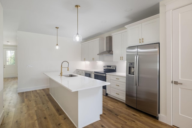 kitchen with wall chimney exhaust hood, white cabinets, light countertops, a sink, and stainless steel appliances