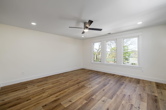 unfurnished room with wood finished floors, ceiling fan, baseboards, and recessed lighting