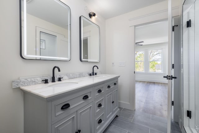 full bathroom featuring tiled shower, double vanity, a sink, and tile patterned flooring