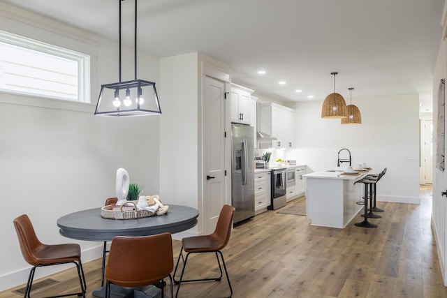 dining space featuring recessed lighting, light wood finished floors, visible vents, and baseboards
