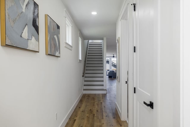 hall with baseboards, recessed lighting, wood finished floors, and stairs