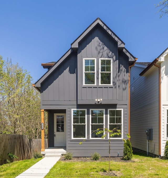 view of front of house featuring board and batten siding, a front yard, and fence