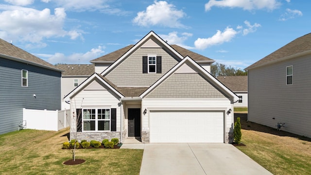 craftsman-style house with driveway, stone siding, a front yard, fence, and a shingled roof