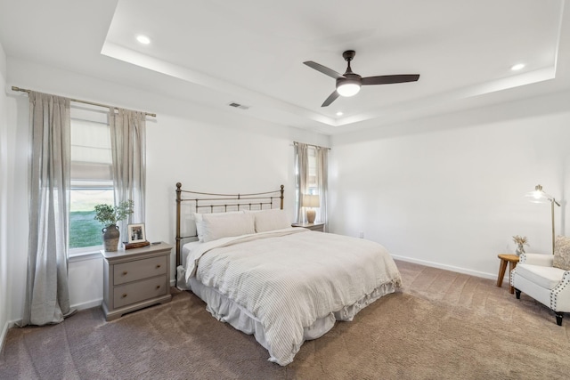bedroom with a tray ceiling, carpet flooring, baseboards, and recessed lighting