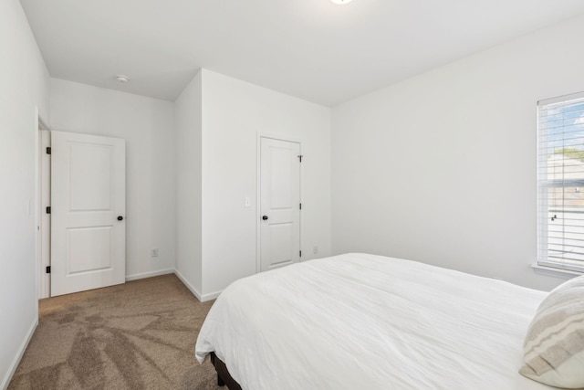 bedroom with baseboards and carpet