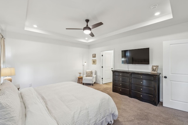carpeted bedroom with recessed lighting, a tray ceiling, baseboards, and ceiling fan